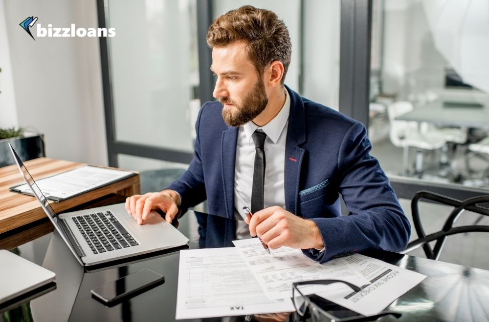 Cash-Flow-Management-Tips-to-Avoid-Bad-Debt-in-Business business owner managing his cashflow while looking at his laptop at the office