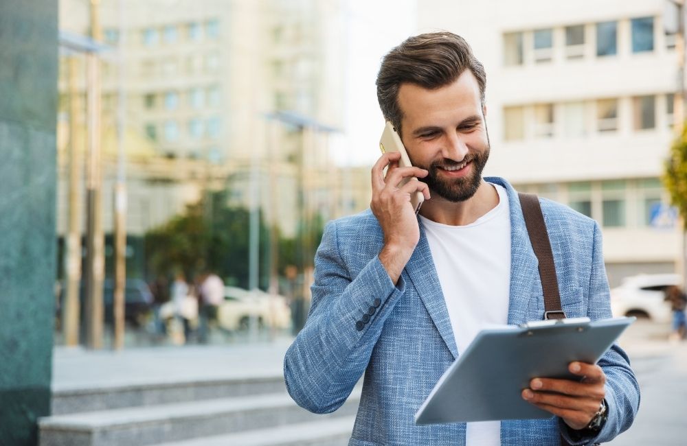 7-ways-to-get-funding-for-your-small-business happy business man talking on mobile phone while checking a document