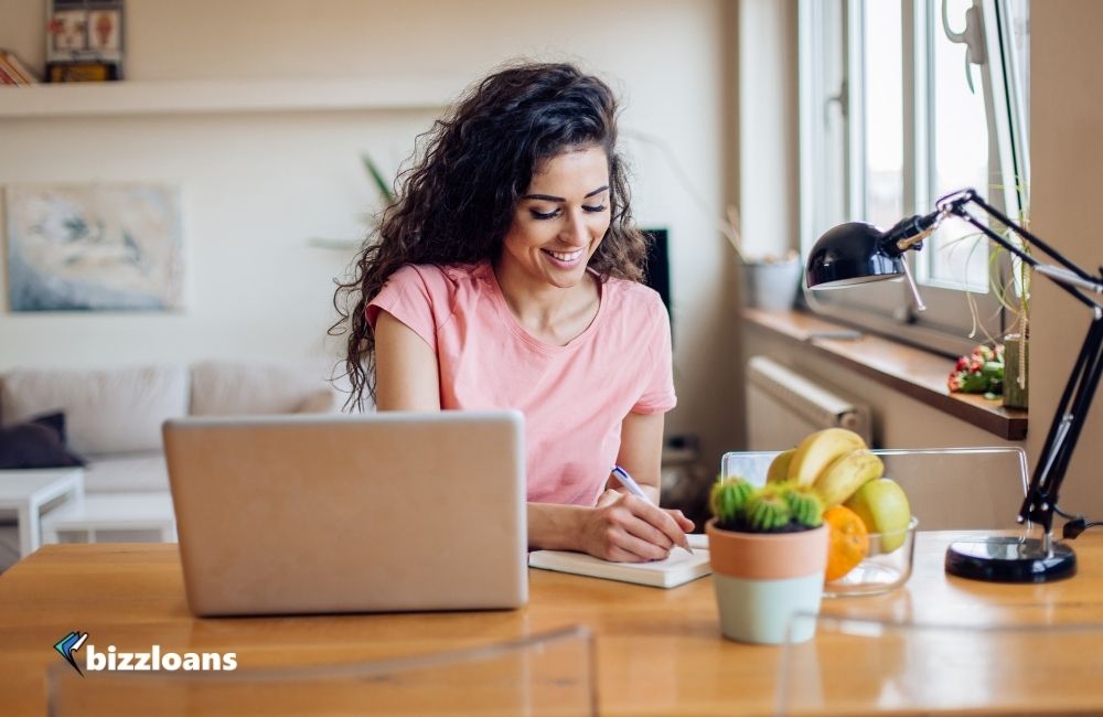 top-8-benefits-of-a-small-business-loan happy business woman applying for a small business loan online at home