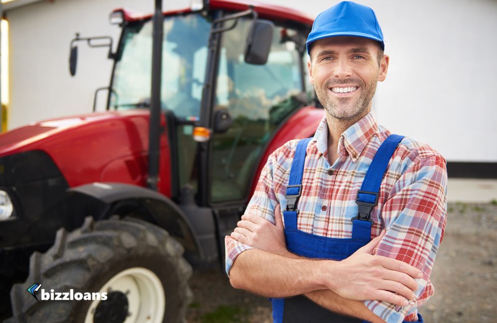 equipment-financing-for-small-businesses smiling business owner in front of heavy equipment